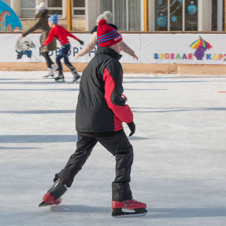 PYATIGORSK, RUSSIA - JANUARY 4, 2015: Open-air ice rink. The boy slides on the iceのeditorial素材