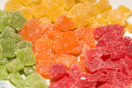 Colorful pieces of candied fruit closeup on white backgroundの写真素材