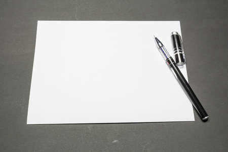 Template blank sheet of paper and a pen on a dark backgroundの写真素材