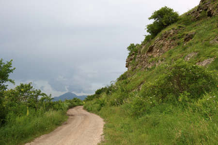 Dirt road in a mountainous area in cloudy weather