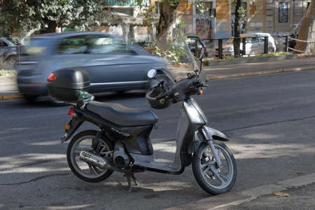 Rome, Italy - August 17, 2015: Black scooter with a top box and a helmet on the handlebars.のeditorial素材