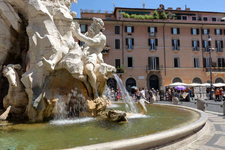 Rome, Italy - August 18, 2015: Details of the Fountain of the four Rivers and walking people in the middle of Piazza Navona.のeditorial素材