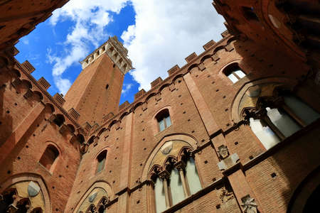 Siena, Italy - August 20, 2015: Bottom-up view from courtyard of Torre del Mangia and Palazzo Pubblico in Siena, Italy. The historic centre of Siena has been declared by UNESCO a World Heritage Siteのeditorial素材