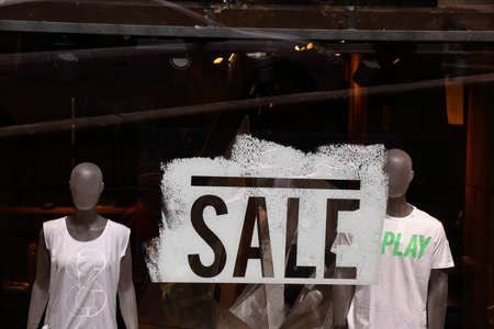 Siena, Italy - August 20, 2015: Shop window with the word SALE and two mannequins in white T-shirtsのeditorial素材