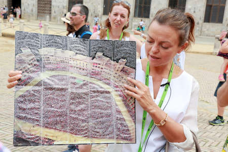 Siena, Italy - August 20, 2015: The guide Irina tells tourists about the Palio di Siena horse race...