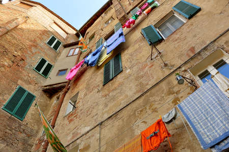 Siena, Italy - August 20, 2015: Walls of the ancient building with windows and the drying linenのeditorial素材