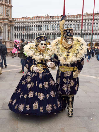 Venice, Italy - February 6, 2018: Unidentified people in beautiful dress and in Venetian masks at St. Mark's Square in Venice. The annual Venice Carnival is from January 27 to February 13 in 2018のeditorial素材