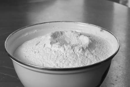White enamel bowl with wheat flour. Monochrome imageの写真素材