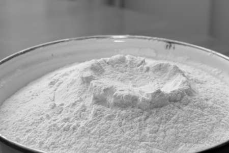 White enamel bowl with wheat flour close-up. Monochrome imageの写真素材