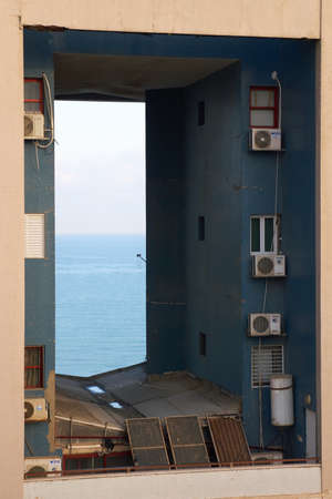 Tel Aviv, Israel - June 6, 2017: View of the gaping hole through the wall of residential building in Tel Aviv. This holes also known as dragon gates in skyscrapersのeditorial素材