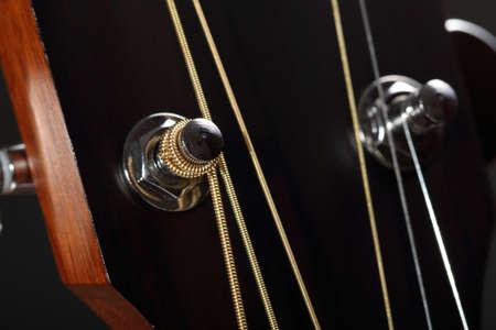Wooden guitar head with strings and tuning pegs close-upの写真素材