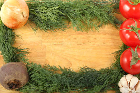 Onion, garlic, beetroot, three ripe tomatoes and bunch of the fresh dill leaves on a wooden cutting...