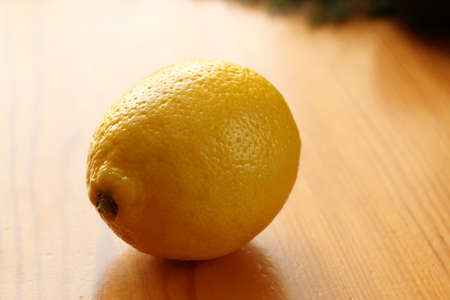 Single fresh ripe lemon on a wooden table in the kitchen. Selective focusの写真素材