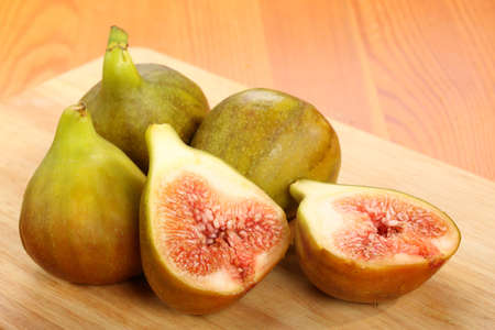 Group of figs with sliced fig on a wooden cutting board. Concept of cooking