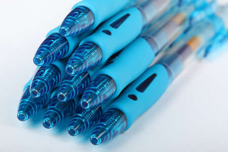 Group of ten blue transparent plastic gel pens on a white background