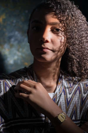 art portrait of a latin american girl. Beautiful mexican woman, on abstract dark background. Artistic dramatic light. Flawless skinの写真素材