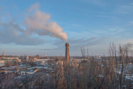 dirty smoke comes from a chimney, an industrial pipe. Waste pollution in the air. Cityscape on a...