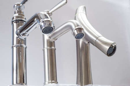 a variety of faucets taps on a white shelf in the store counter
