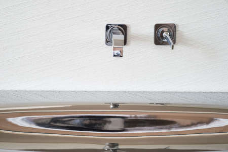 faucet mixer built into the wall. Close-up stainless steel washbasinの写真素材