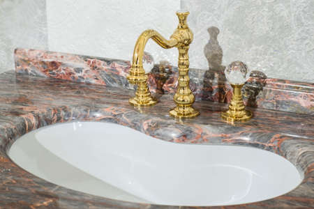 sink made of expensive marble stone. Vintage design of faucet and faucets, in gold and glass handles. Stained glass expensive bathroom designの写真素材