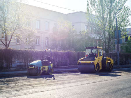 road repair work. A team of working engineers, laying asphalt. Cars asphalt stealers, ride the roadの写真素材