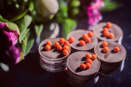 bouquet of beautiful flowers and chocolate on wooden surface