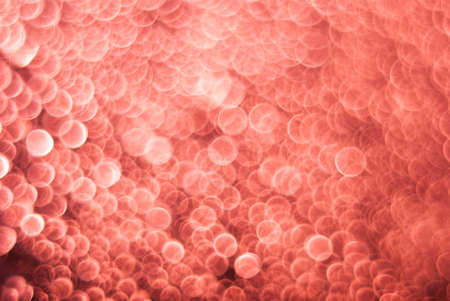 Living Coral color glitter bokeh gradient background. Festive sparkles. Color of the Year 2019.