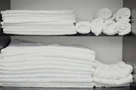 close-up of a male hair care master, washes a mans head in a sink after cutting his hair. Professional male hair care in barbershop. white towels on a shelf in a barber shopの写真素材