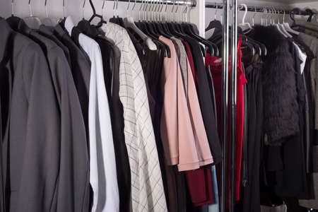 clothes hanger atelier designer clothes shop. Close-up of diverse women's clothing. In the clothing store, business women's suits, fur products, sweaters, and leather clothesの写真素材