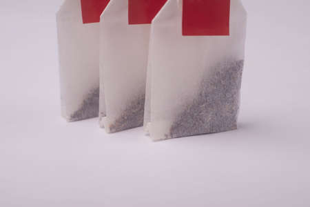 tea bag with a red label on a white background. Close-up advertising photo of tea bags