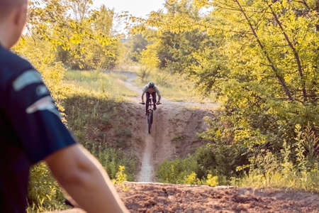 athlete, cyclist rides on a road in the forest. Cycling