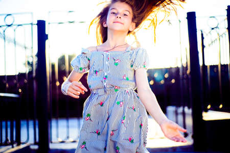 Cute little girl jumping on white bedの写真素材