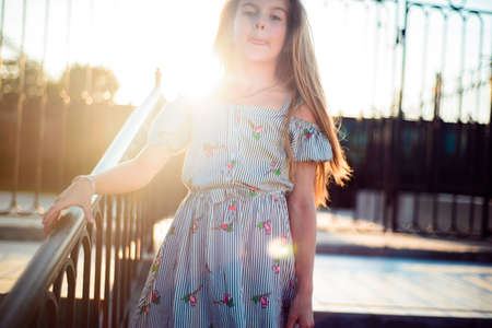 portrait of a beautiful little girl in a dress. Plays with her beautiful hair. Fashionable child, beautiful model appearance.の写真素材