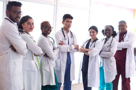 medical students, doctors, mixed race. A team of young people in white coats posing in the hallway of the hospitalの写真素材