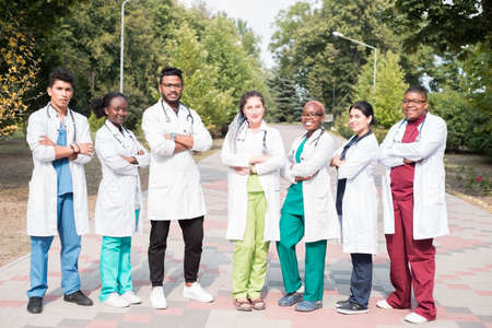 team of young doctors, mixed race. Posing in the photo, for advertising. People in white coats, with phonendoscopes, outdoorsの写真素材
