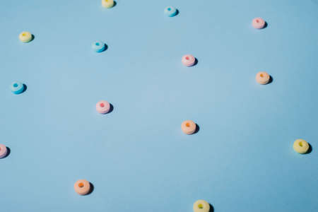 multi-colored round sweets, with a hole in the center. On a blue background. Minimalism conceptの写真素材