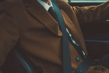 Closeup portrait of a bearded guy in a business suit, fastens his seat belt, sitting behind the wheel of a car. Safety equipment fastens seat belt driverの写真素材