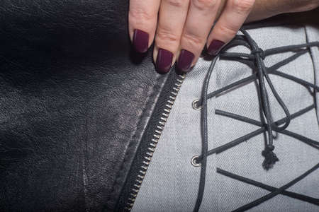 In the catalog of photo advertising, the model is dressed in a gray skirt and a leather jacket in...