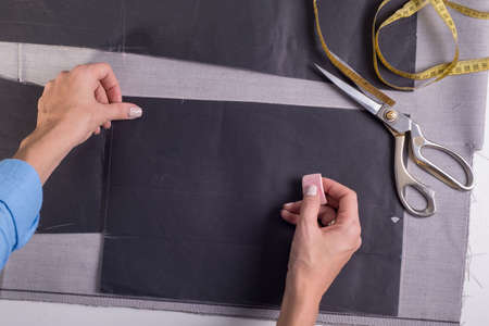 top view of the work of the hands of a master in the manufacture and sewing of clothes. Girl...