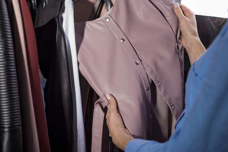 portrait of a beautiful red-haired girl, in a women's clothing store, selects and tries on a skirt...