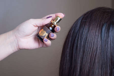 Zaporozhye. Ukraine. Beauty club prima vera. close-up of a hairdresser holding a Nashi hair care tool against the backdrop of the client's flawless hairのeditorial素材