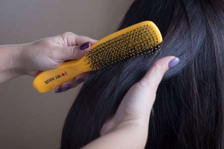 Spa body care products, hair brush natural Closeup of a hairdresser combing his hair with a yellow...