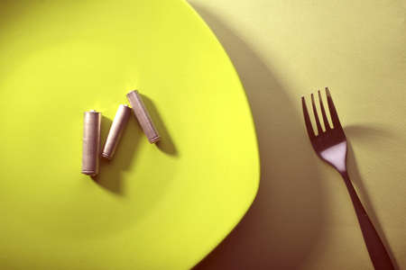 used batteries on a green plate. Near the plug. Reuse. Environmental pollution concept