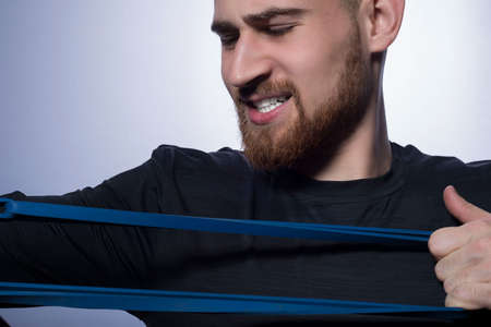 closeup portrait of a young handsome bearded athlete guy, with an aggressive grimace, gritting his...