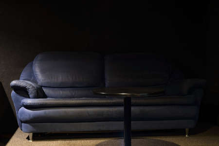 dirty sofa in old room Portrait of an old sofa with a table in the VIP hall of the cinema. The worn texture of a worn sofa.の写真素材