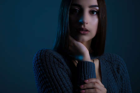Art studio of a dramatic portrait of a young beautiful girl, with artistic retouching. Close-up, girl's face, with an expressive look. On a dark background.の写真素材