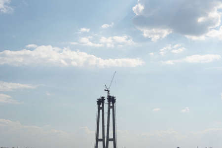 bridge structure in the city, against a background of green trees, and a cloud. The construction of a bridge in Ukraine, the city of Zaporozhye.の写真素材