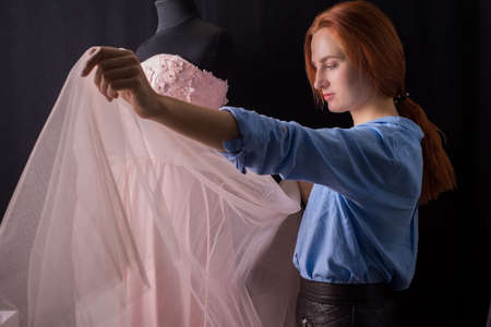 wedding delicate pink dress on a mannequin, in the manufacturing process. In a design studio. A...