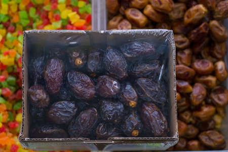 Dried dates Fruit store counter with dried fruits. In plastic containers, the fruits of dried dates. Healthy food. natural nutrition. Vegetarian Productsの写真素材