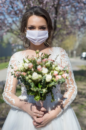 bride in protective mask. Wedding during the period of quarantine and pandemic wedding.の写真素材